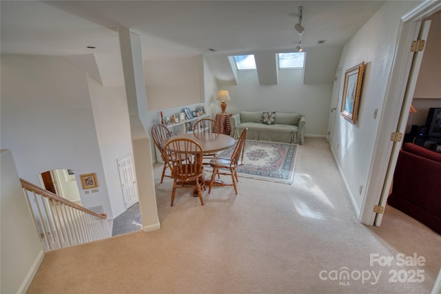 dining area featuring light carpet and a skylight