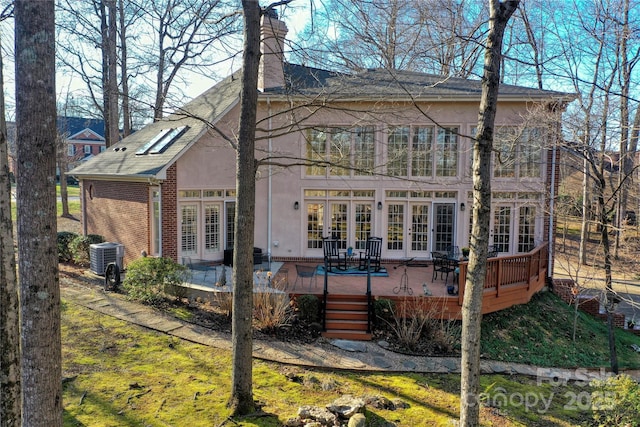 back of property with a wooden deck, french doors, and central air condition unit