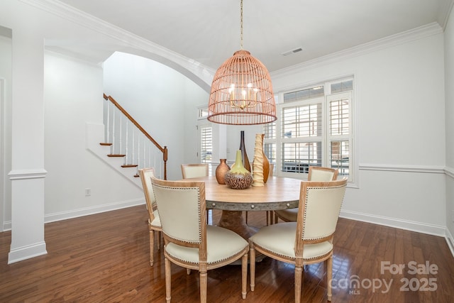 dining area featuring dark hardwood / wood-style floors, crown molding, and a chandelier