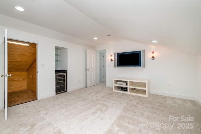 unfurnished living room with carpet, lofted ceiling, and wine cooler