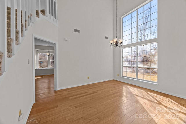 interior space featuring a notable chandelier, a high ceiling, and hardwood / wood-style floors