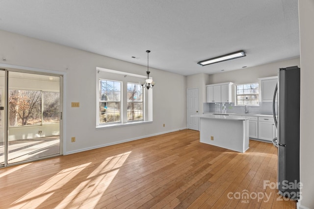 interior space featuring light hardwood / wood-style floors, sink, a textured ceiling, and a chandelier