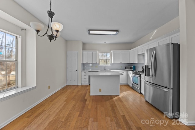 kitchen featuring white cabinetry, pendant lighting, and appliances with stainless steel finishes