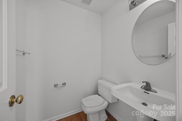 bathroom featuring sink, toilet, and hardwood / wood-style floors