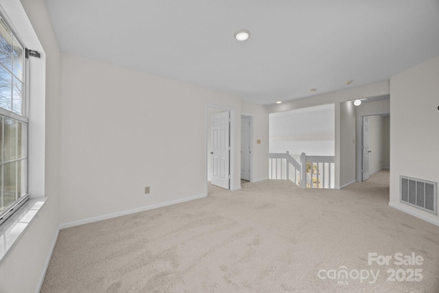 spare room featuring a healthy amount of sunlight and light colored carpet