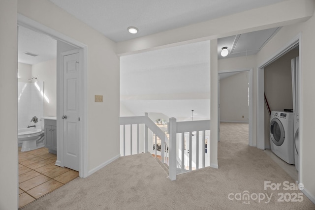 hall featuring light colored carpet and separate washer and dryer