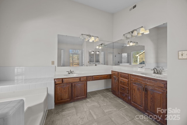 bathroom with a healthy amount of sunlight, a tub to relax in, and vanity