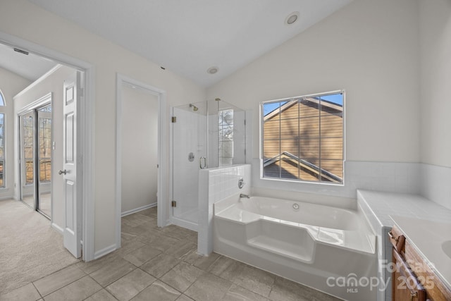 bathroom featuring vanity, tile patterned flooring, lofted ceiling, and plus walk in shower