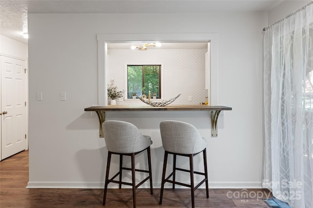 interior space featuring a kitchen bar and dark hardwood / wood-style flooring