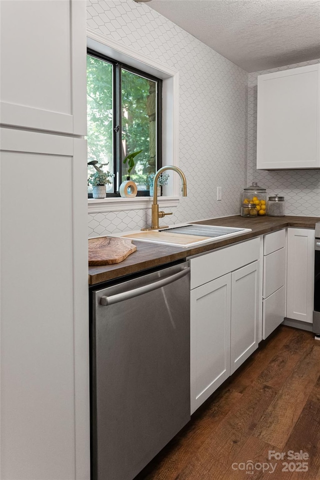 kitchen featuring white cabinetry, sink, dark hardwood / wood-style flooring, a textured ceiling, and appliances with stainless steel finishes