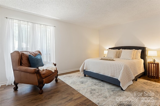 bedroom featuring hardwood / wood-style flooring and a textured ceiling