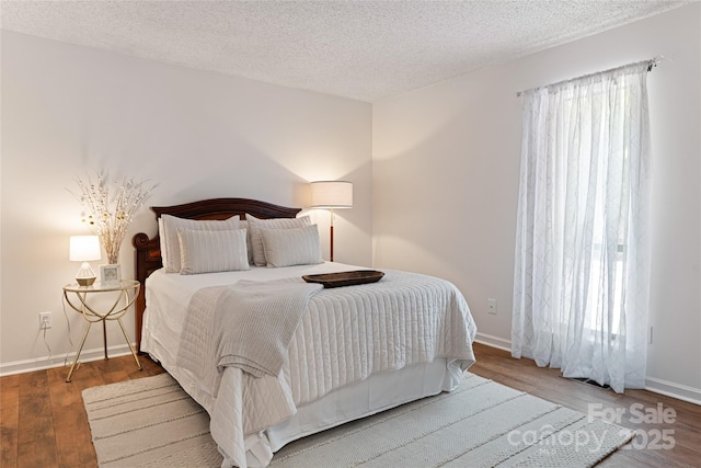 bedroom with hardwood / wood-style floors and a textured ceiling