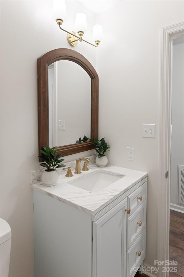 bathroom featuring vanity and toilet