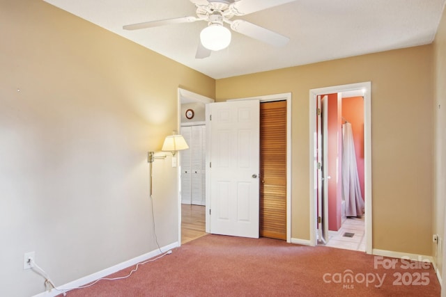 unfurnished bedroom with ceiling fan, a closet, and light carpet