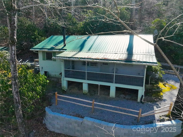 exterior space featuring a sunroom and metal roof