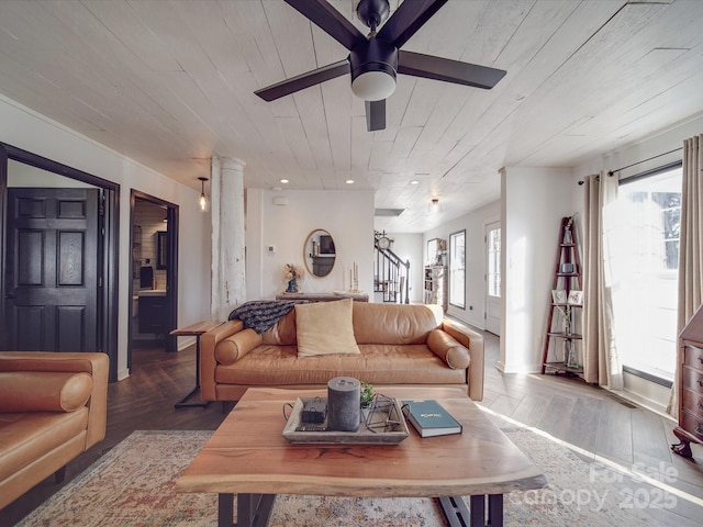 living room featuring ceiling fan, wood finished floors, wood ceiling, stairs, and decorative columns