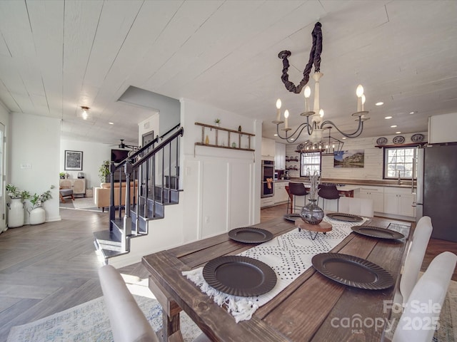 dining room featuring wooden ceiling, stairway, and a chandelier