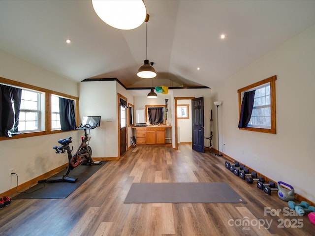 exercise room featuring lofted ceiling, baseboards, wood finished floors, and recessed lighting