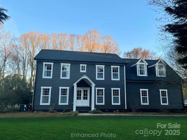 colonial-style house with french doors and a front lawn