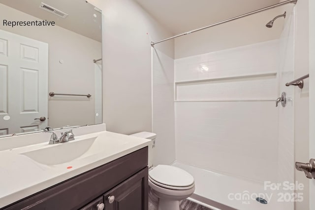 bathroom with toilet, vanity, and walk in shower