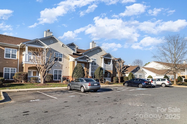 view of property with uncovered parking and a residential view