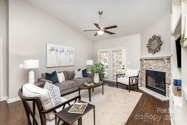 living area featuring dark wood finished floors, a fireplace, vaulted ceiling, and ceiling fan