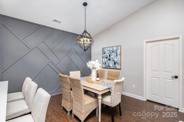 dining room featuring baseboards, visible vents, wood finished floors, vaulted ceiling, and a notable chandelier