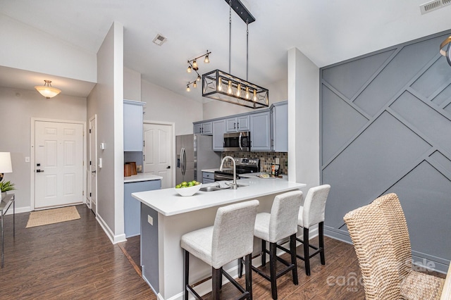 kitchen with stainless steel appliances, gray cabinets, light countertops, visible vents, and vaulted ceiling