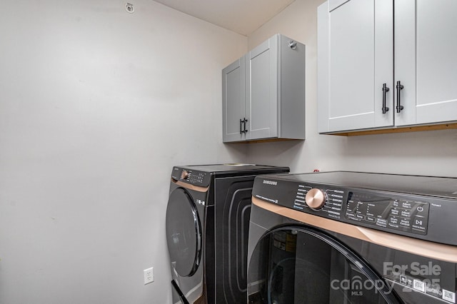 laundry area with independent washer and dryer and cabinet space