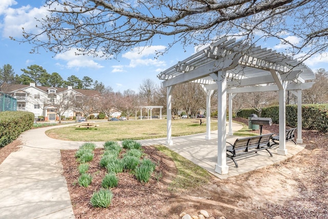 view of home's community featuring a lawn and a pergola