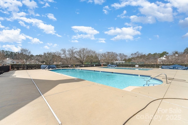 community pool featuring a patio area and fence