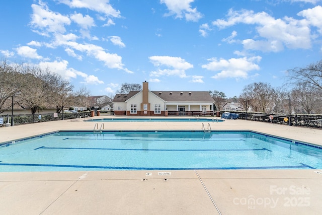 pool featuring a patio area and fence