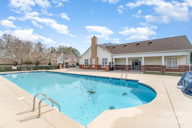 pool with fence and a patio