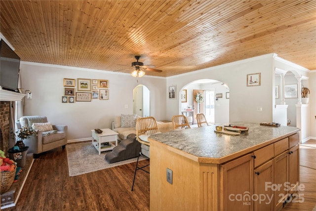 kitchen with dark wood-type flooring, a center island, a breakfast bar, and wood ceiling