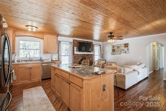 kitchen featuring light brown cabinetry, wooden ceiling, stainless steel dishwasher, and a center island