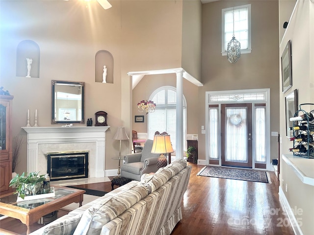 entrance foyer with a fireplace, dark hardwood / wood-style flooring, and a towering ceiling