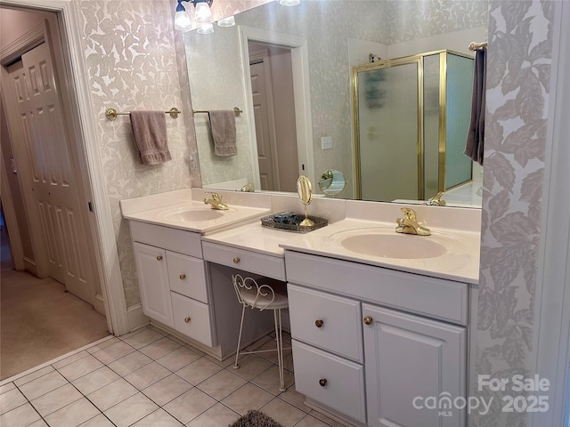 bathroom with a shower with shower door, vanity, and tile patterned floors