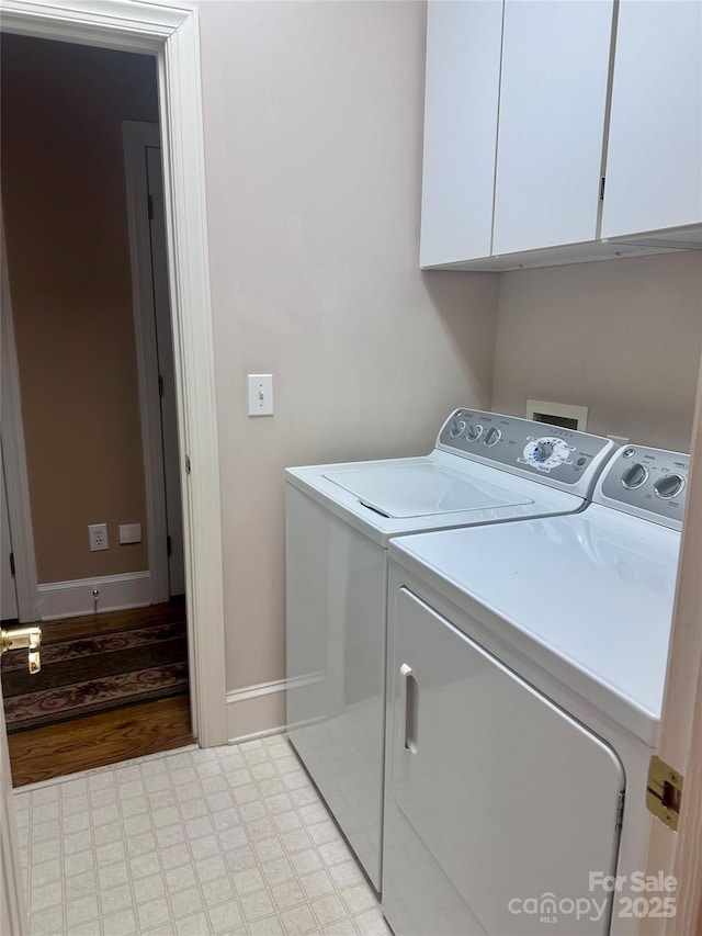 washroom with cabinets and washing machine and dryer