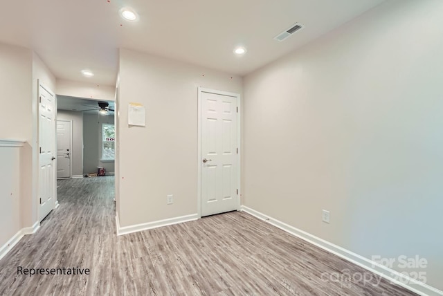 unfurnished room with ceiling fan and light wood-type flooring