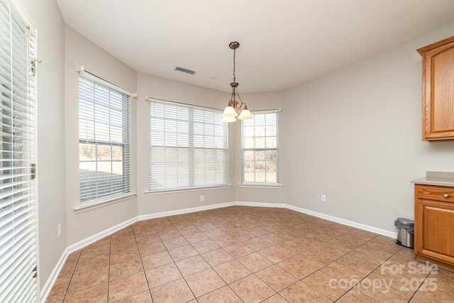 unfurnished dining area with light tile patterned floors and a chandelier