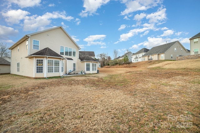 back of property with a yard and a patio