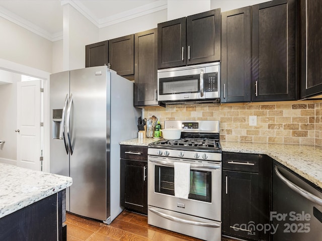 kitchen featuring backsplash, stainless steel appliances, crown molding, light stone countertops, and dark brown cabinets