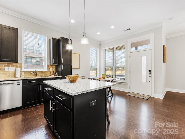 kitchen featuring dark hardwood / wood-style floors, a center island, light stone counters, decorative light fixtures, and stainless steel dishwasher