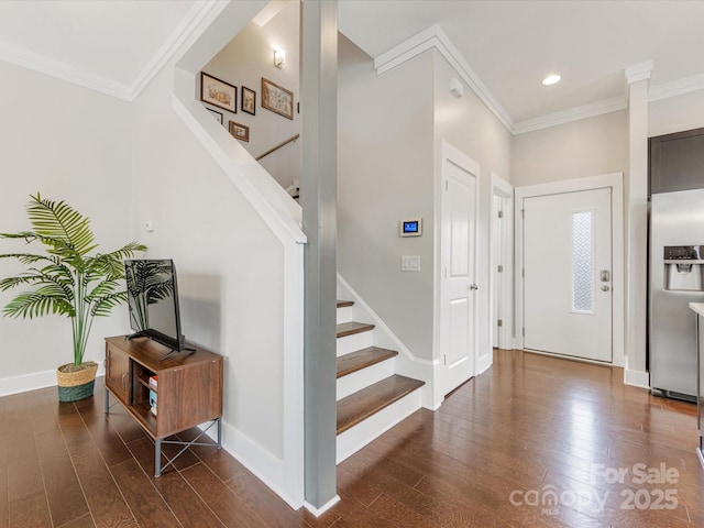 foyer entrance with ornamental molding and dark hardwood / wood-style flooring