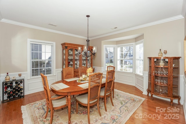 dining room featuring a chandelier, ornamental molding, and hardwood / wood-style flooring