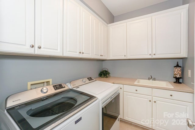 laundry area featuring sink, cabinets, and washer and clothes dryer