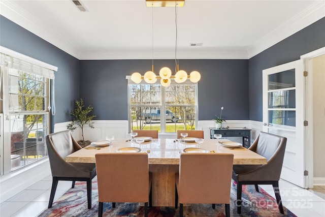 dining space with tile patterned floors and crown molding