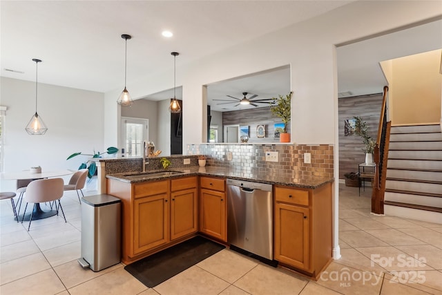 kitchen featuring sink, light tile patterned floors, dishwasher, and hanging light fixtures