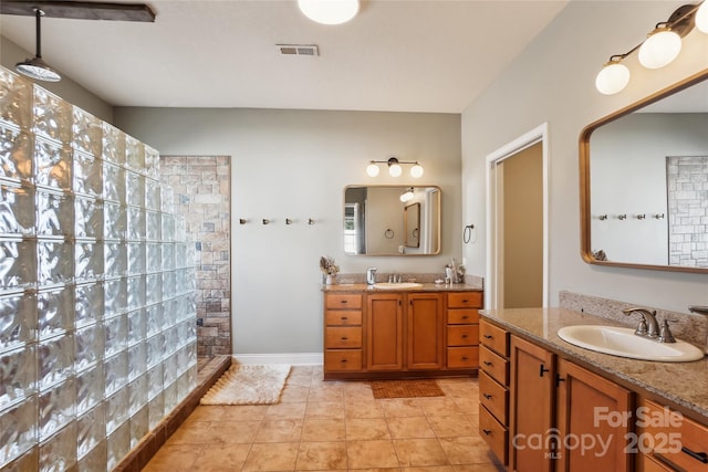 bathroom with walk in shower, tile patterned flooring, and vanity