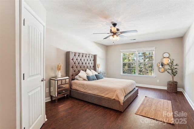 bedroom with a textured ceiling, ceiling fan, and dark hardwood / wood-style floors